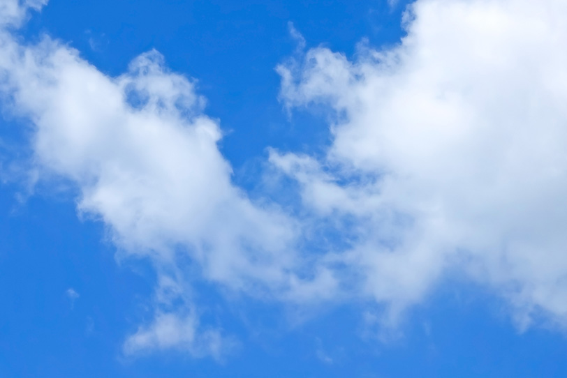 綿のような雲が浮かぶ青空の写真画像