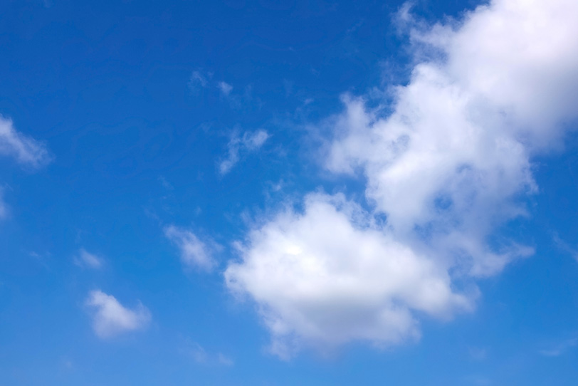青空を登るように浮かぶ白い綿雲の写真画像
