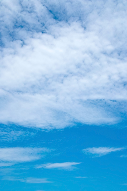 青空の上に被さる白い斑雲の写真画像
