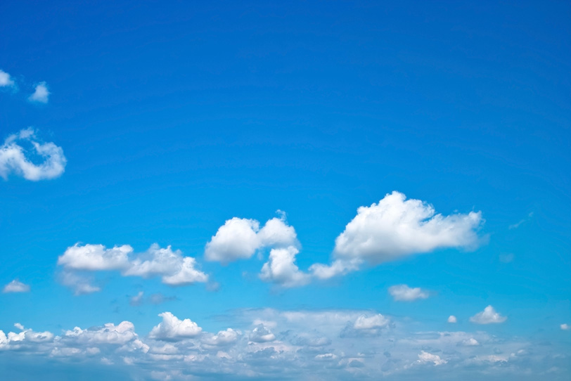 透き通った青空に群がる雲の写真画像