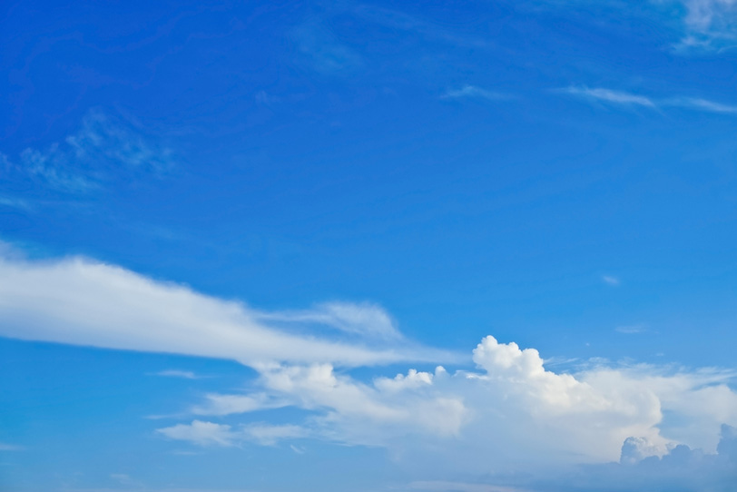 遠くに積乱雲が浮かぶ夏の青空の写真画像