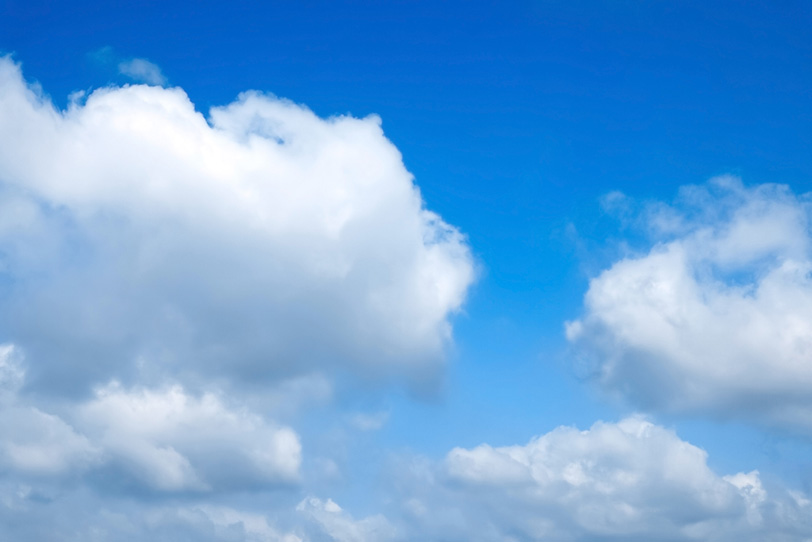 空を這うように流れる積雲群の写真画像
