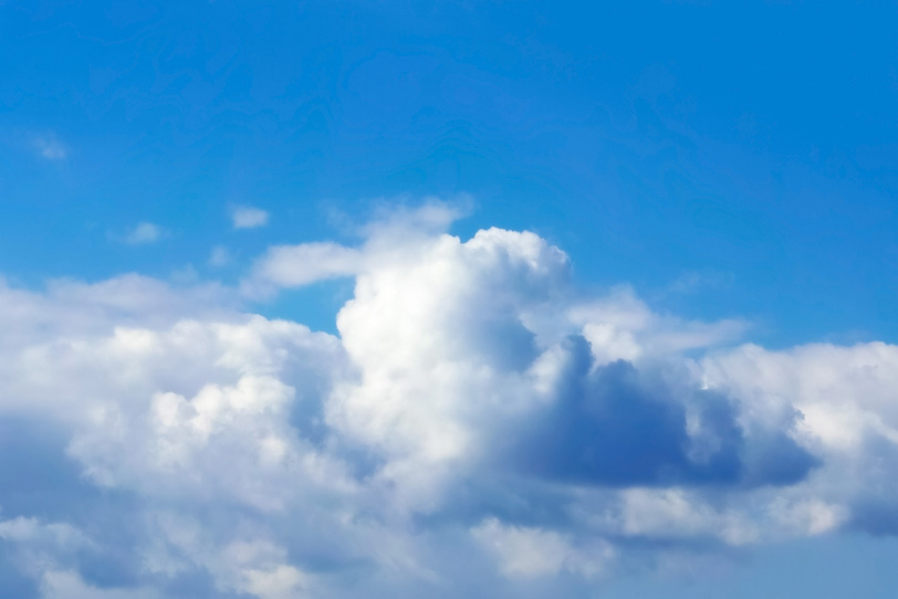 綿のような雲が横に広がる青空の写真画像