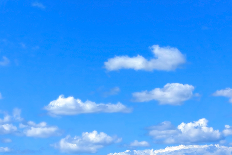 平らな雲が浮かぶ穏やかな青空の写真画像
