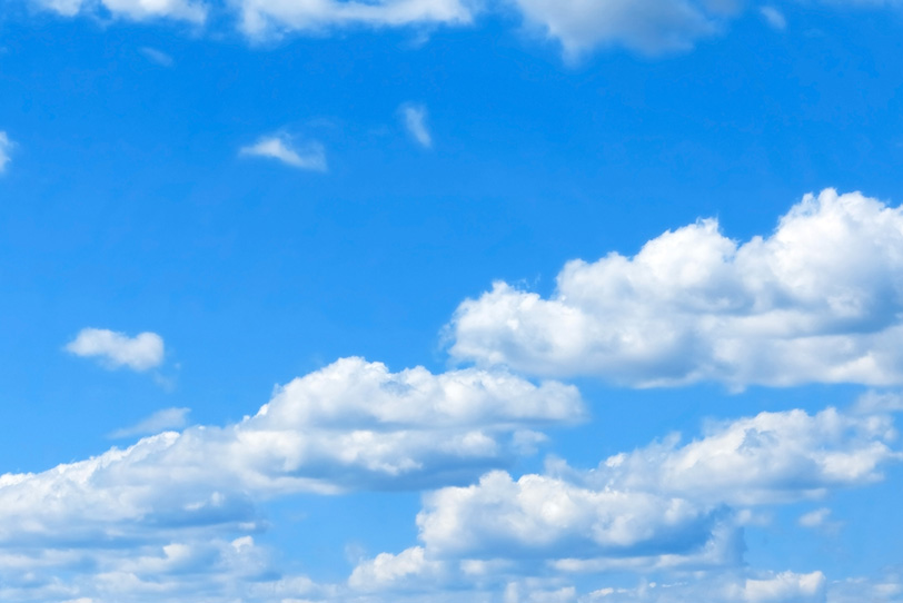 青空に列をなして移動する扁平雲の写真画像