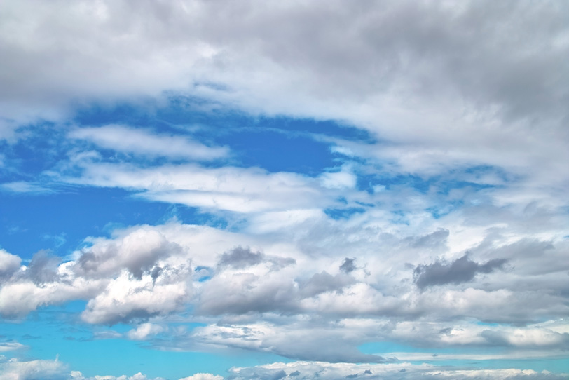雲多き日のざわめく青空の写真画像