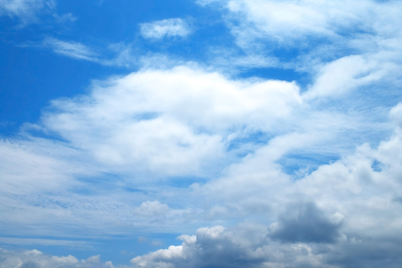 青空に尾を引いて流れる大きな雲の写真画像