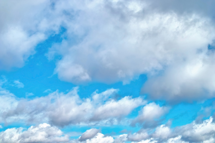 流れる雲の隙間から見える青空の写真画像