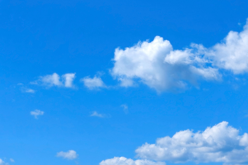 透き通る青空を直進する雲の写真画像