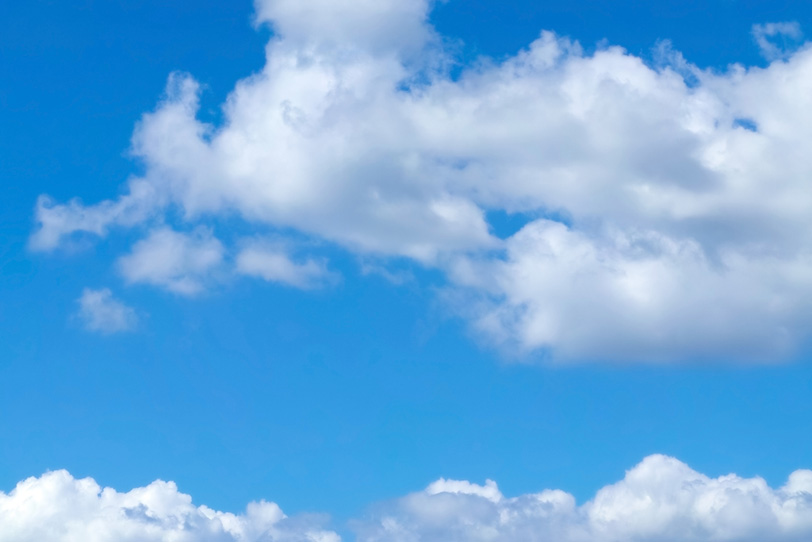 青空を水平に広がる二つの雲の写真画像