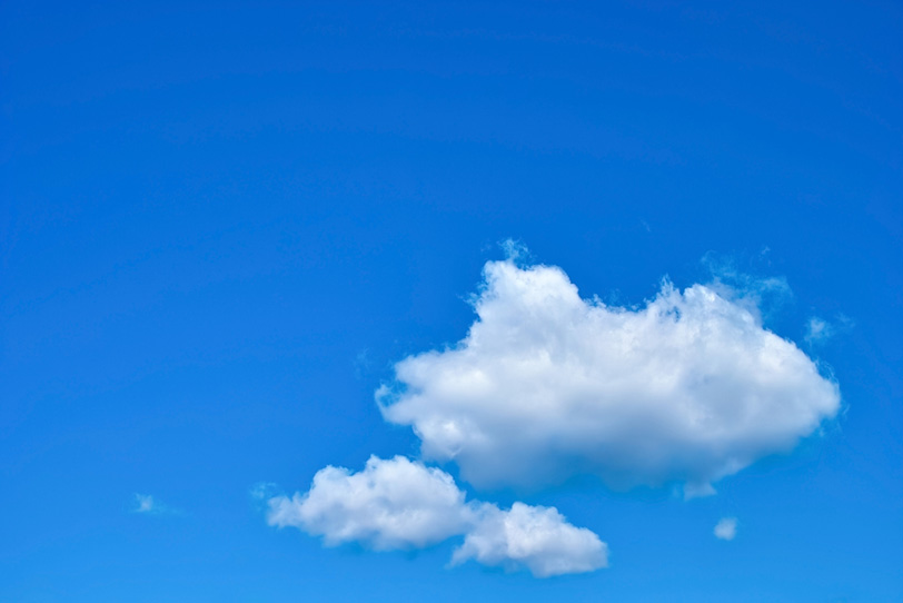 広い青空を浮標する三つの綿雲の写真画像
