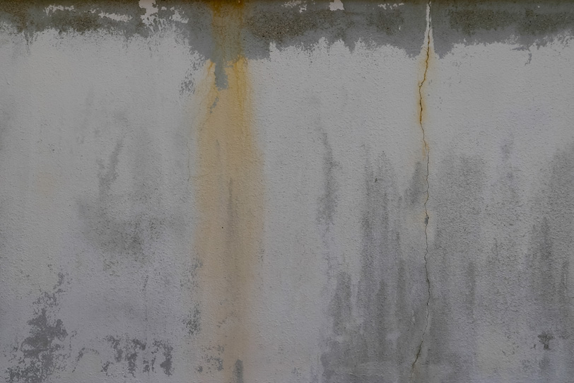 劣化したモルタルの壁の写真画像