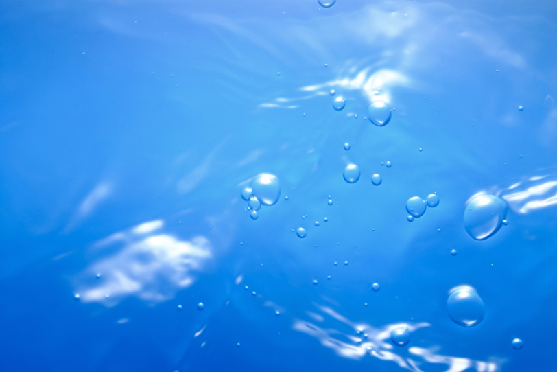 コバルトブルーの水面に浮かぶ泡の写真画像