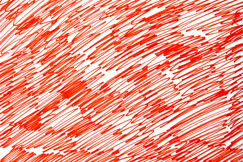 白い紙に赤ペンで描く無数のストロークの写真画像