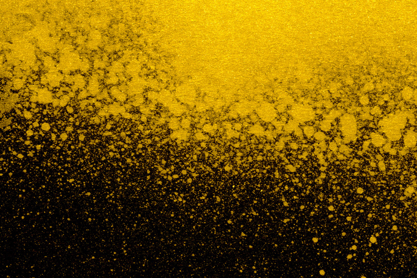 ゴールドの飛沫と黒の背景の写真画像