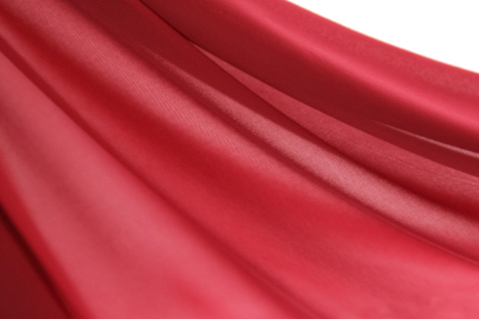波打つ様なシワがある赤の布地の写真（布 ドレープの背景フリー画像）