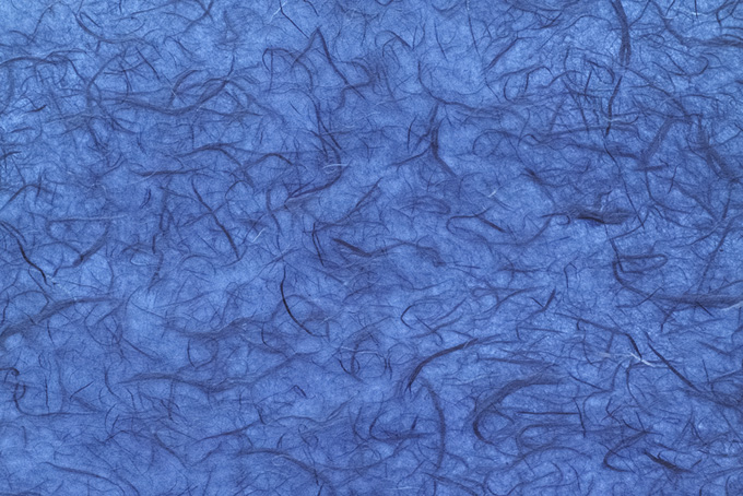 楮繊維が幾つも入った群青色和紙のテクスチャ素材（和紙 青色の背景フリー画像）