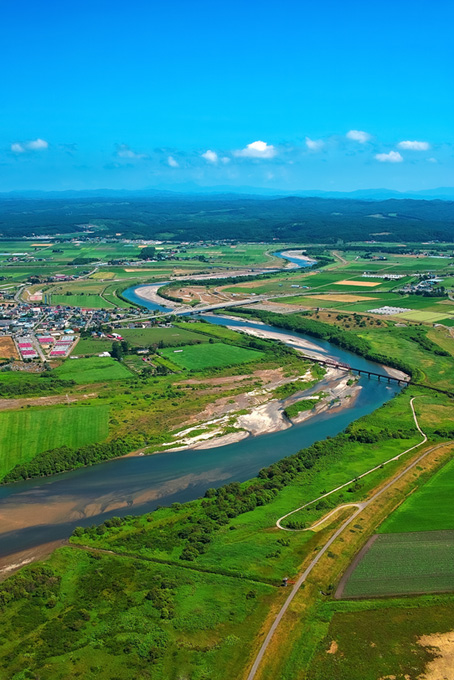 綺麗な川の流れる田舎町（風景 写真の背景フリー画像）