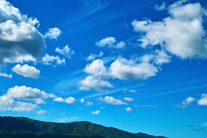 山の上を流れる白い雲の画像（山の背景フリー画像）