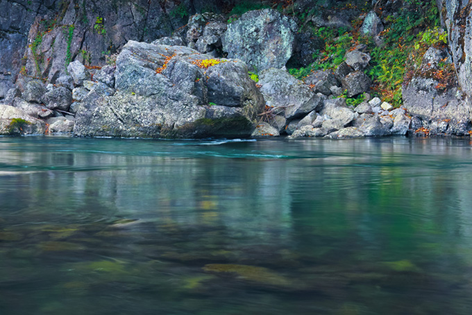 川底が見えるエメラルドグリーンの水と岩（清流の背景フリー画像）