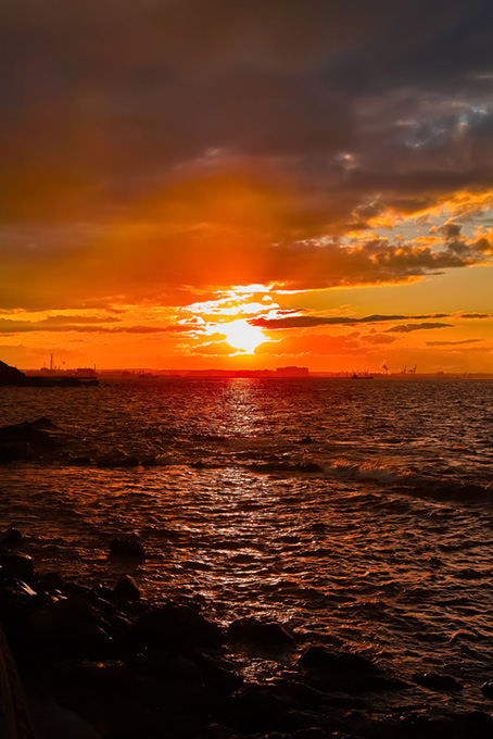 夕日が沈む臨海の町(背景 夕景 画像のフリー画像)