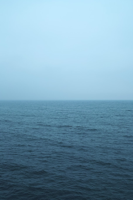 薄曇りの空と暗い海（海 風景の背景フリー画像）