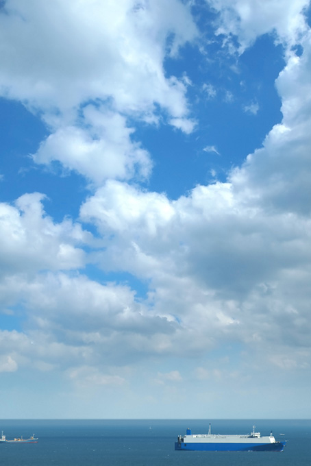 空の下を進む大きな船（海 風景の背景フリー画像）