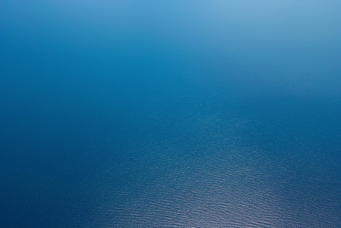 光を反射する紺碧の海（海 写真の背景フリー画像）