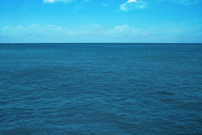 青空と穏やかな青い海（海 写真の背景フリー画像）