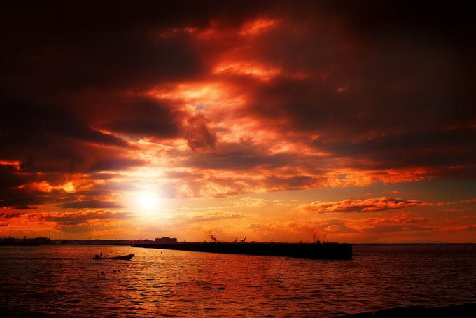 夕焼けの港と沖に向かう舟（夕景 写真の背景フリー画像）