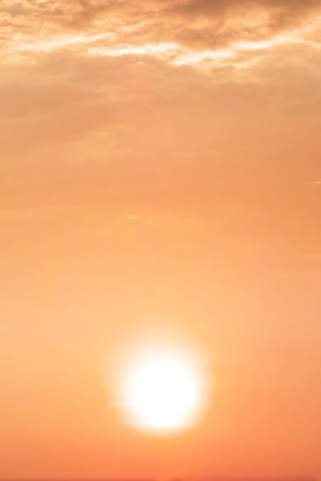 夕焼けに暈ける大きな夕陽（夕焼け 素材の背景フリー画像）