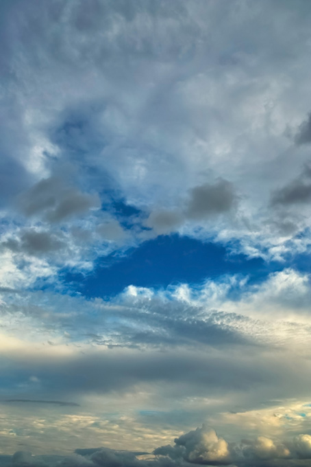 多様な雲の隙間から覗く青空（空 写真の背景フリー画像）
