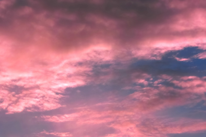 夕焼けの雲がピンクに染まる（空 素材の背景フリー画像）