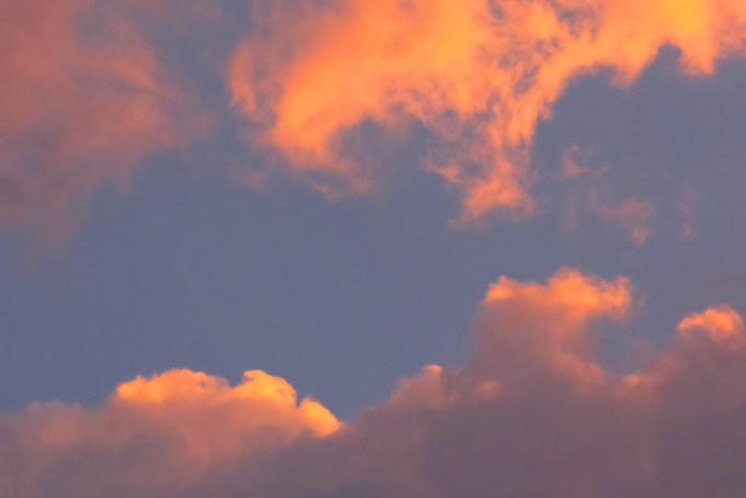 夕焼けに橙色の雲が踊る（空 素材の背景フリー画像）