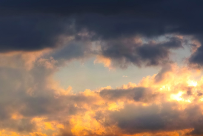 夕焼けの雲に黒と橙が混ざる（空 風景の背景フリー画像）