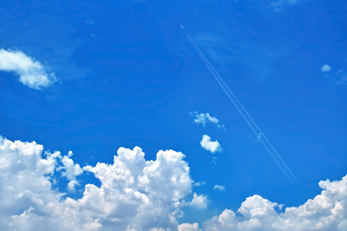 夏の空を駆け上る飛行機雲（青空 背景のフリー画像）