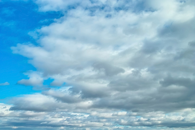 清澄な青空を覆い尽くそうとする雲（空 写真の背景フリー画像）