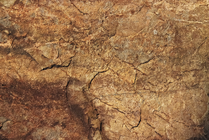 ヒビの入った茶色い岩肌（岩 石の背景フリー画像）