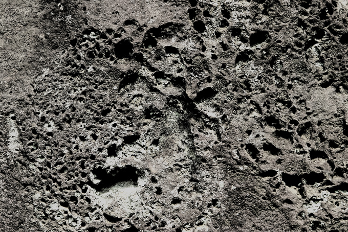 丸い穴が幾つも開いた石の素材（石 背景のフリー画像）