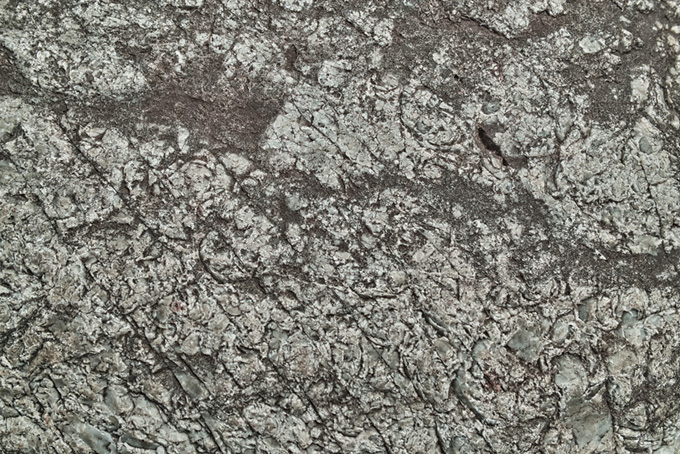 無数の傷が入った石の表面の写真（石 岩肌の背景フリー画像）
